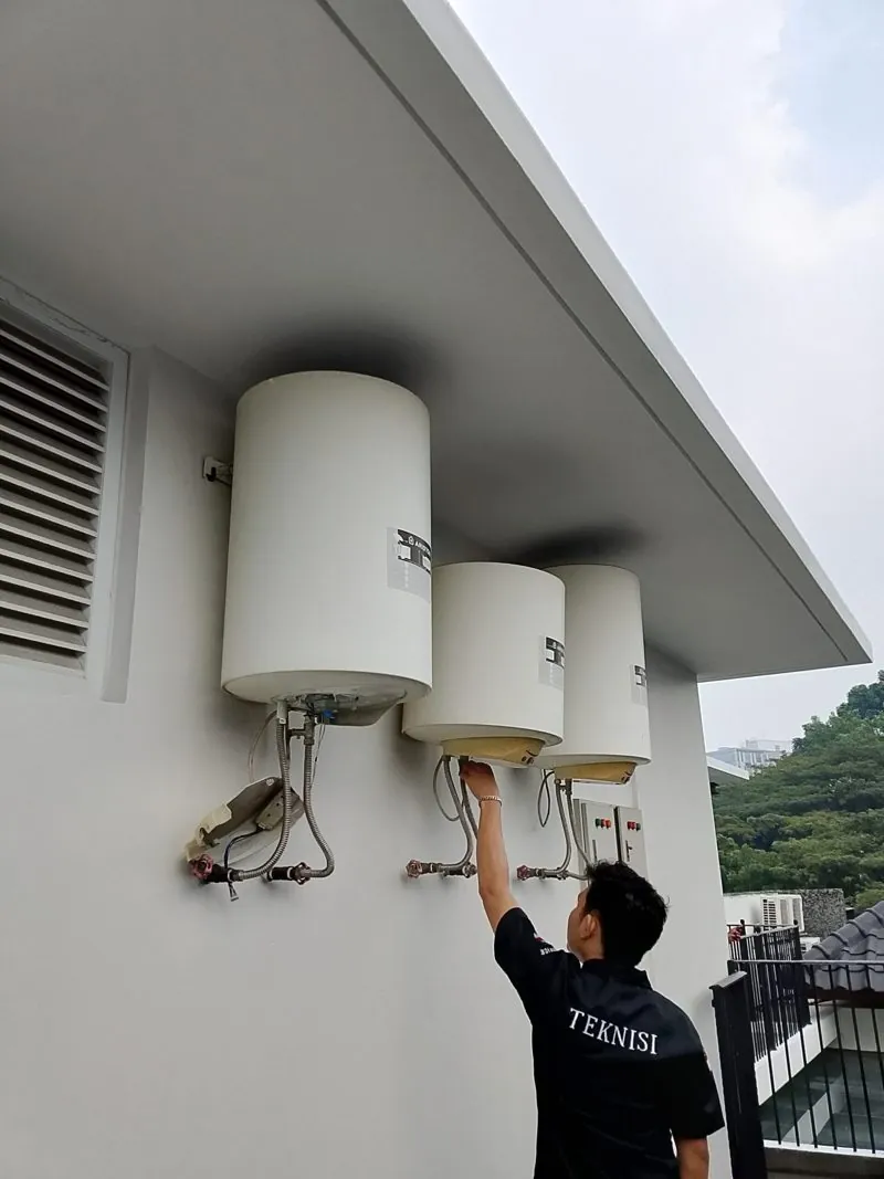 Service water heater listrik tangki Tangerang: teknisi memeriksa tiga unit di dinding luar rumah