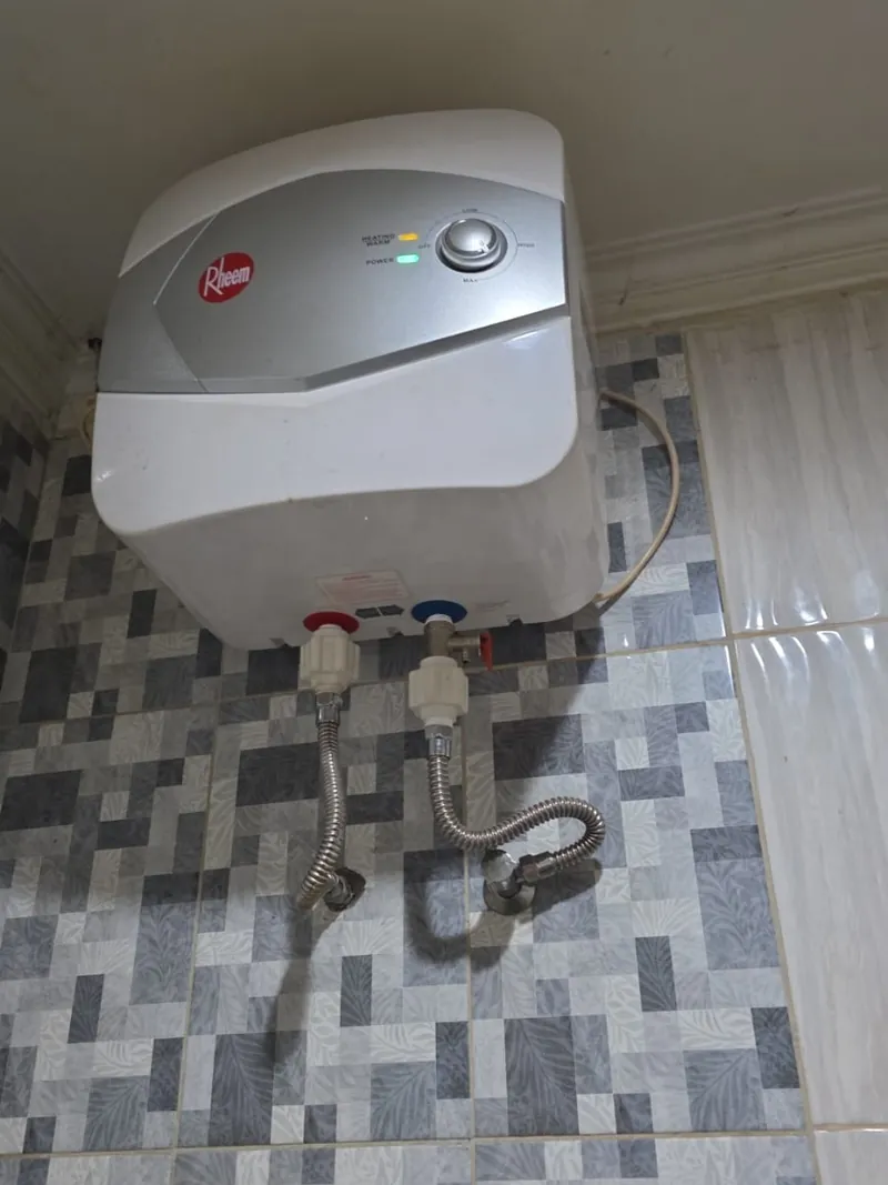 Service water heater listrik Rheem Tangerang terpasang di dinding kamar mandi